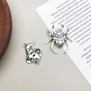 Macro detail of vintage silver spider and witch head charms for Halloween jewelry making