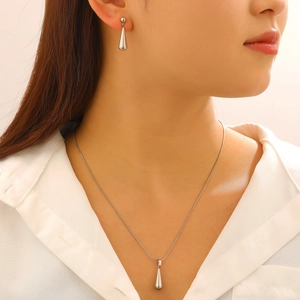 Detailaufnahme eines silbernen Wassertropfen-Schmucksets mit passender Kette und Ohrringen