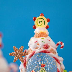 Lighted Christmas gingerbread house water globe with festive candy details and gold glitter