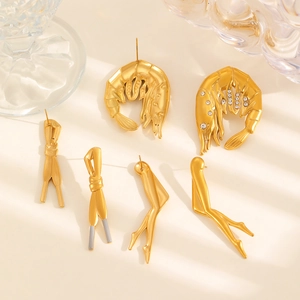 Vue détaillée des boucles d'oreilles créatives dorées en forme de crevette avec strass