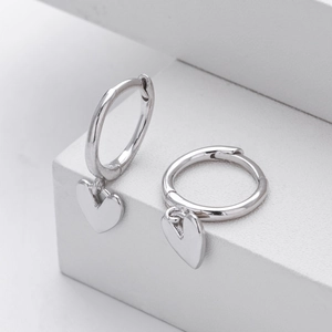 Elegant S925 sterling silver hoop earrings with polished heart charms on minimalist white podium
