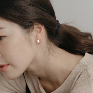 Minimalist S999 sterling silver star stud earrings worn on female ear for style