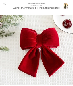 Macro shot of large burgundy velvet Christmas bow with soft plush texture and pine detail