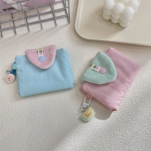 Close-up of macaron-colored fabric card holders with plush flaps and cute animal charms