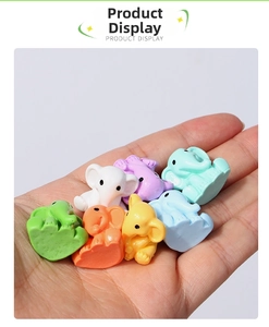 Macro view of colorful mini resin elephants held by hand to show their tiny size