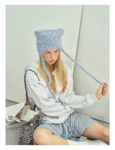 Detail of light blue fluffy cat ear hat with long tassels and soft faux fur texture