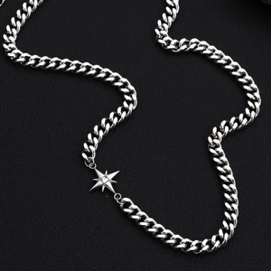 Macro shot of silver Cuban chain with star pendant and crystal on dark leather background