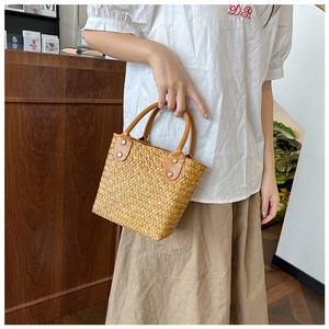 Minimalist straw woven handbag with brown leather handles and buckle for casual styling
