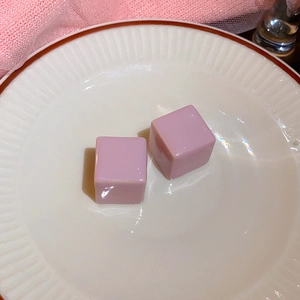Vista macro di pietre di opale rosa a forma di cubo su un piatto bianco con rete