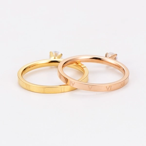 Detail shot of Roman numeral rings in gold and rose gold with zircon inlay