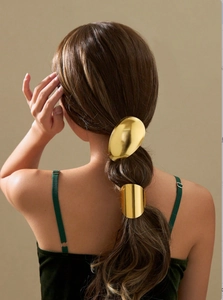 Rear view of gold oval metal elastic hair tie set on ponytail with high gloss finish