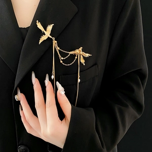 Golden phoenix brooch with pearl tassels pinned on a black suit jacket lapel