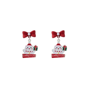 Detail of Christmas snowman earrings with red bow and pearl accents on white background