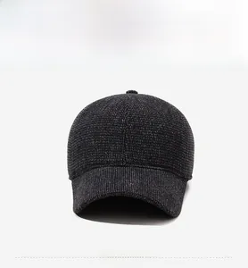 Detail of dark grey wool baseball cap showing metal logo and thick knit texture