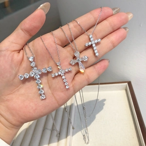 Detailed close-up of four silver cross pendants with shimmering zirconia stones