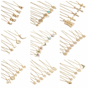 Collection of gold plated necklaces with various charms like heart and evil eye on white background