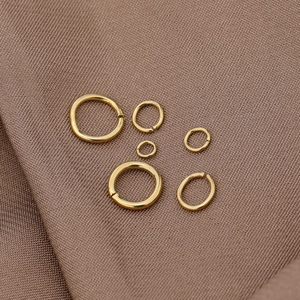 Various sizes of 18K gold plated stainless steel open jump rings on brown fabric
