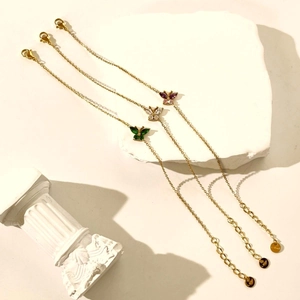 Detail of 18K gold butterfly bracelets with green, white, and purple zircon stones
