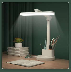 Foldable white LED desk lamp with pen holder feature on a wooden study table