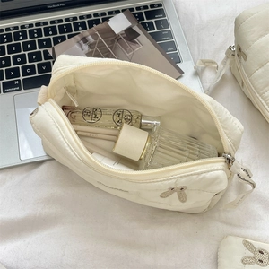 Quilted makeup bag detail featuring cute bunny embroidery and zip closure with ribbon