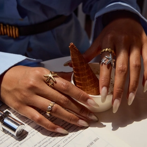 Starfish and seashell rings in gold and silver finish worn by a model in nature light