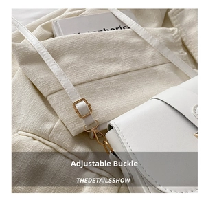 Detail of white leather shoulder bag featuring golden metal adjustable buckle and strap