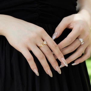 Close-up of gold and silver S925 heart-shaped zircon rings on model's finger