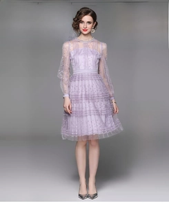 Close-up of purple lace dress featuring intricate floral embroidery and pearl details