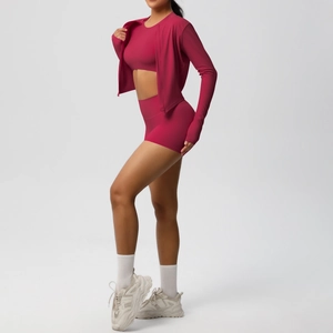 Dettaglio del set fitness 3 pezzi con asole per i pollici e pantaloncini a vita alta magenta