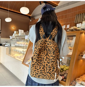 Close-up of leopard print corduroy backpack texture worn in a warm cafe setting