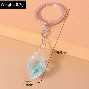 Detailed macro view of glow-in-the-dark blue resin conch keychain with measurements