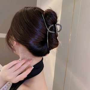 Silver minimalist irregular metal hair claw clip styled on a brown hair bun