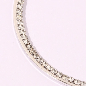 Macro shot of silver-toned curved earrings with micro-paved crystal rhinestones