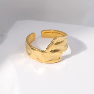 Macro shot of the irregular gold wavy texture on the adjustable stainless steel ring