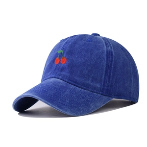 Detailed close-up of vintage washed navy baseball cap with red cherry embroidery