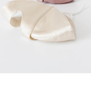 Close-up of champagne gold silk face mask showing luxurious smooth satin texture