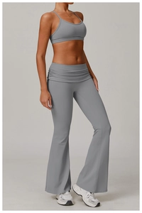 Detail view of high-waisted flare yoga pants with gathered waist and matching grey sports bra