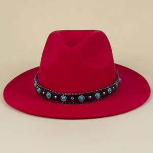 Detailed close-up of red felt fedora hat featuring a turquoise and silver studded band