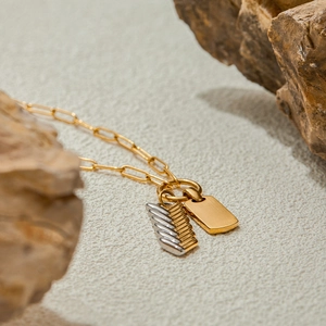 Macro shot of 18K gold-plated comb pendant and lapis lazuli stone on rugged rock