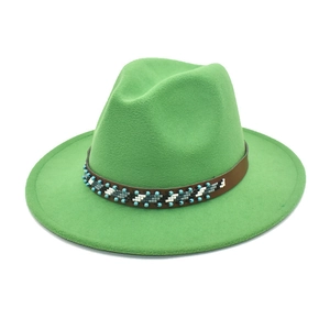 Détail d'un chapeau en laine vert avec ruban en cuir orné de perles de style ethnique