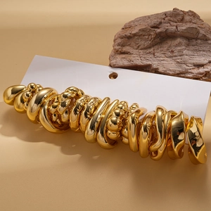 Détail macro d'un ensemble de 20 boucles d'oreilles géométriques dorées sur carte