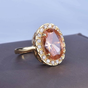 Luxurious 18k gold plated ring with large oval orange gemstone and halo diamonds