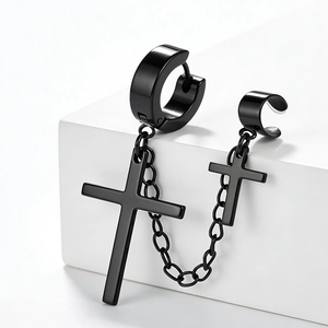 Close-up of black stainless steel cross chain earrings on a white geometric display stand