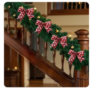 Red and black plaid Christmas bow with paw prints on festive staircase garland