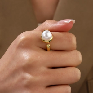 Close-up of a minimalist 18k gold plated open ring featuring a large white baroque pearl