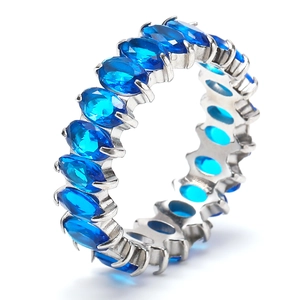 Close-up of eternity ring with oval blue stones and silver plating in claw setting