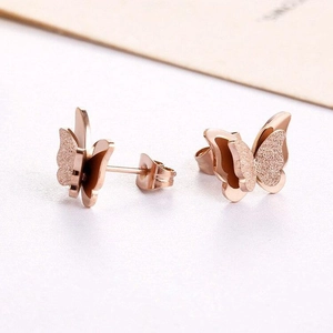 Macro shot of rose gold butterfly earrings with frosted and polished dual textures