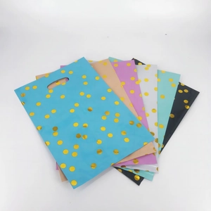 Close-up of colorful polka dot party gift bags with gold foil finish and die-cut handles