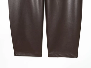 Dettaglio dei polsini dei pantaloni in pelle marrone scuro con cuciture rifinite