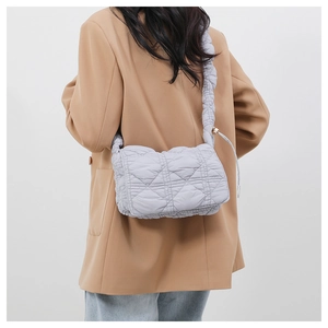 Detail of light purple quilted nylon crossbody bag with ruffled strap and diamond pattern